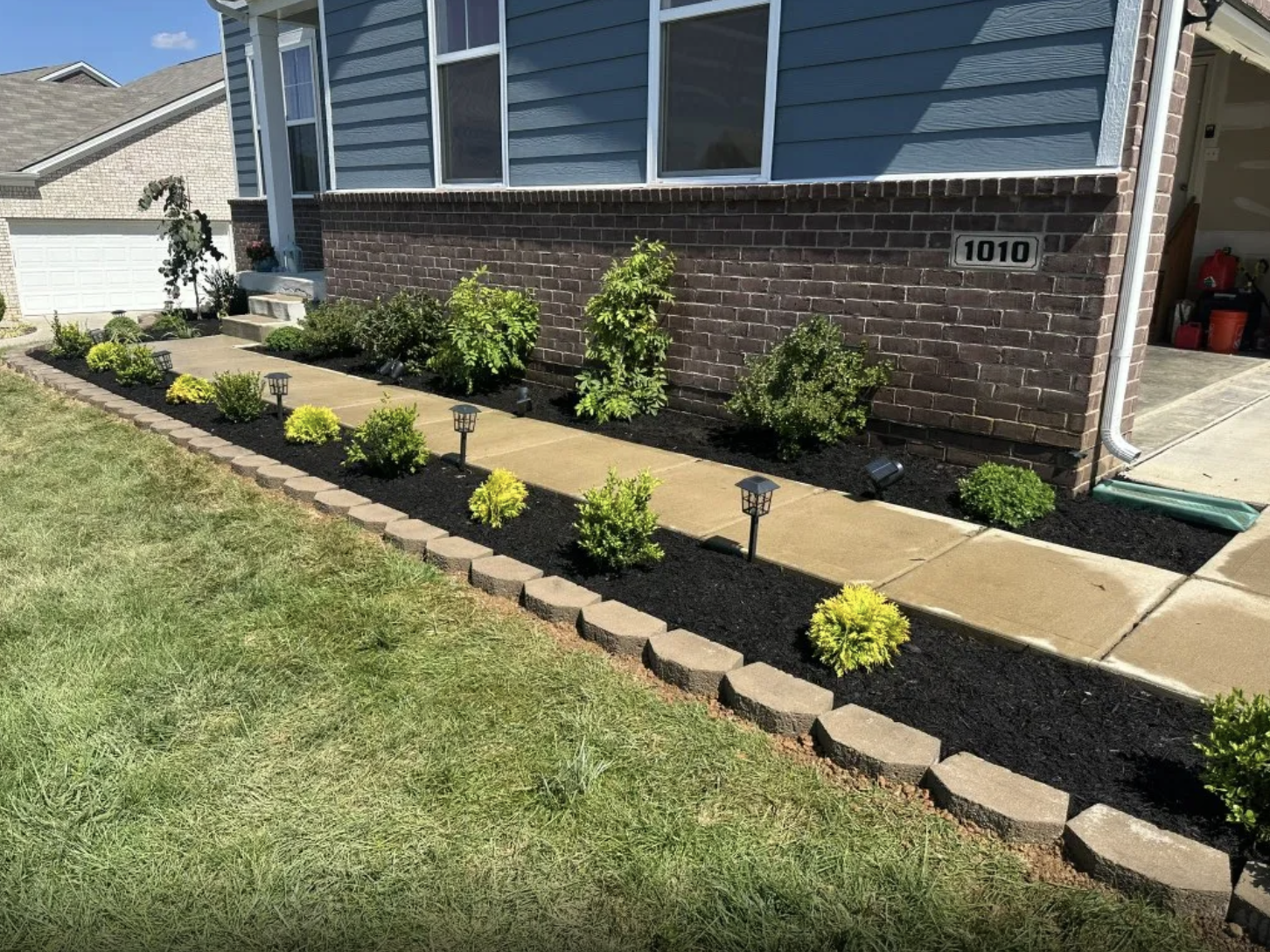 Manicured front walkway with fresh mulch and shrubs